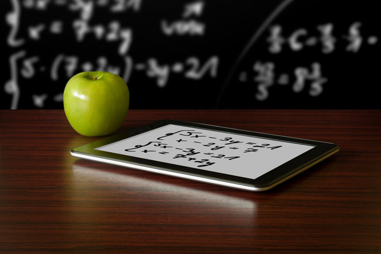 A tablet on a teacher's desk in a classroom.